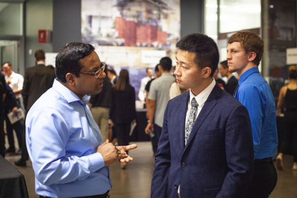 A potential employer speaks with a student at a career fair